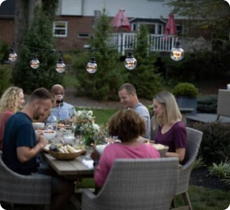 A photograph of an outdoor gathering seated at a table